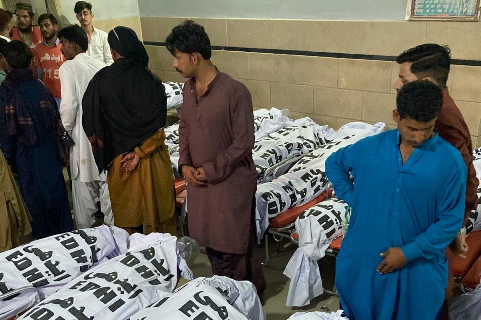 People wait to collect the body of their relative who were died in a bus crash, at a morgue in Karachi, Pakistan (AP)