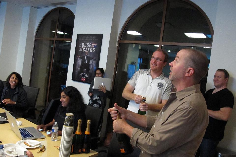 In this Thursday, July 11, 2013, photo, Chris Jaffee, Netflix VP of Product Innovation, pops the cork on a champagne bottle after the debut of the new series "Orange is the new black" in Los Gatos, Calif. (AP Photo/Michael Liedtke)