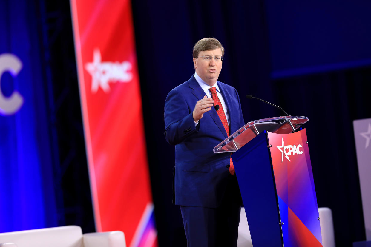 Tate Reeves, Republican governor of Mississippi, giving a speech at a lectern with the letters CPAC on it.