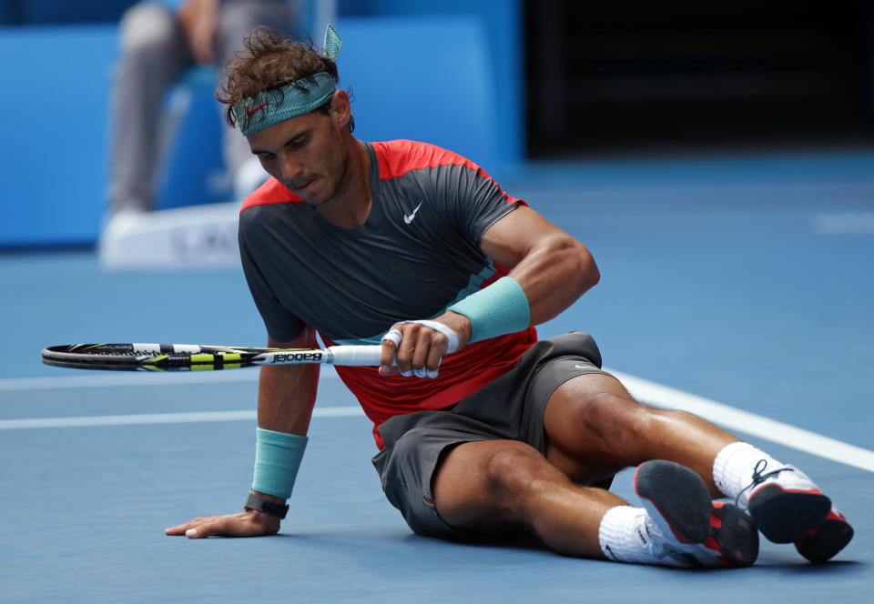 Rafael Nadal of Spain gets up after he fell during his fourth round match against Kei Nishikori of Japan at the Australian Open tennis championship in Melbourne, Australia, Monday, Jan. 20, 2014.(AP Photo/Aaron Favila)