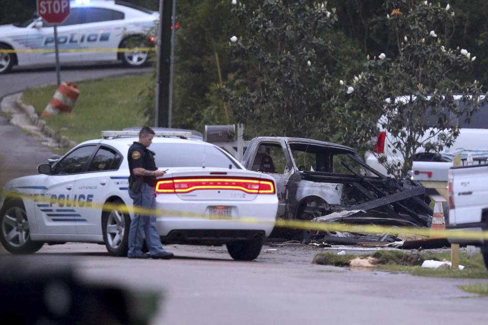 Hattiesburg police surround a burned automobile and a damaged home after a small plane crashed late Tuesday night in Hattiesburg, Miss., Wednesday May 5, 2021. Emergency officials in Mississippi say multiple people were killed when the small plane crashed into a home. (AP Photo/Chuck Cook)