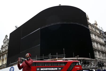 A double decker bus passes the advertisement boards at Piccadilly Circus which have been switched off prior to being replaced with more modern screens, in central London, Britain January 16, 2017. REUTERS/Stefan Wermuth,