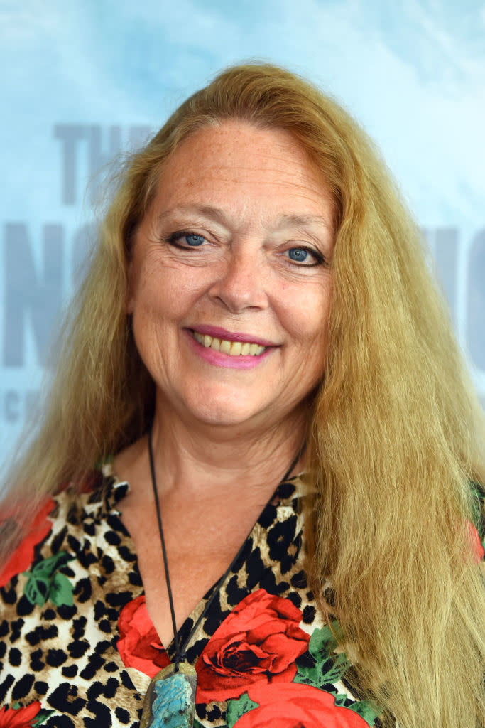 Smiling woman in floral print outfit at an event