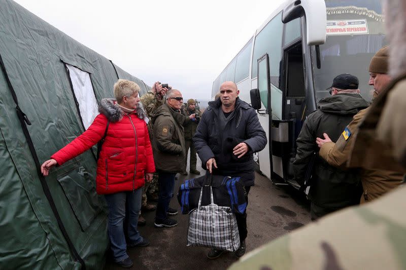 Ukrainian citizens get off a bus following the exchange of prisoners of war between Ukraine and the separatist republics in Donetsk region