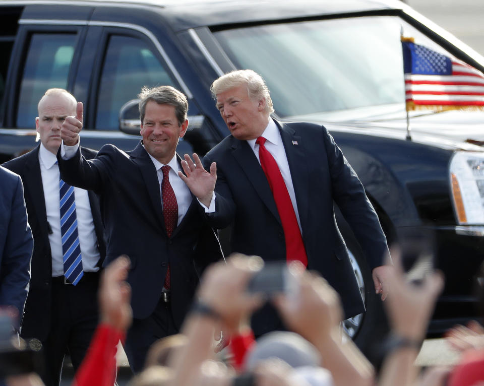 Georgia Republican gubernatorial candidate Brian Kemp, left, walks with President Donald Trump as Trump arrives for a rally Sunday, Nov. 4, 2018, in Macon , Ga. (AP Photo/John Bazemore)