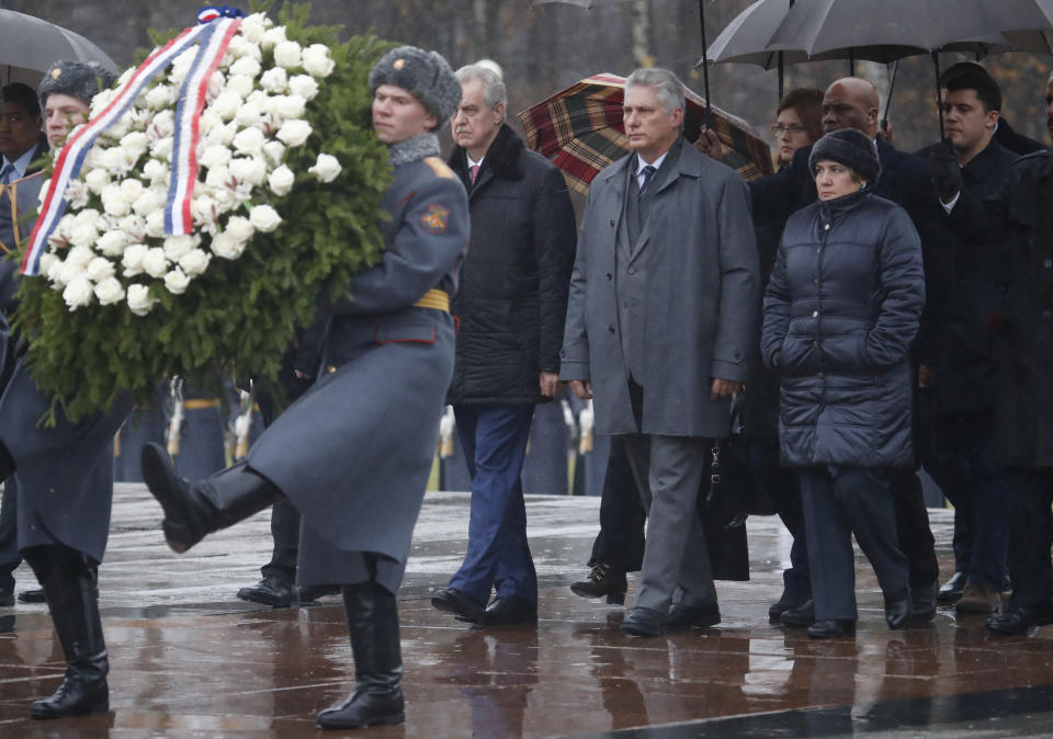 Cuban President Miguel Diaz-Canel, 3rd right, and his wife Lis Cuesta, 2nd right, take part in the wreath laying ceremony at the WWII memorial at the Piskaryovskoye cemetery in St.Petersburg, Russia, Sunday, Oct. 27, 2019. Cuban President Miguel Diaz-Canel is on a working visit to Russia. (AP Photo/Dmitri Lovetsky)