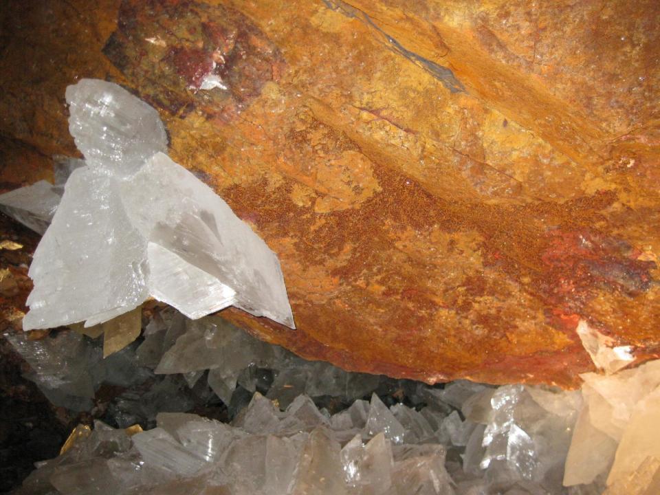 This image provided by Penny Boston shows a red wall in a cave with butterfly crystal. In a Mexican cave system so beautiful and hot that it is called both Fairyland and hell, scientists have discovered life trapped in crystals that could be 50,000 years old. The bizarre and ancient microbes were found dormant in caves in Naica, Mexico, and were able to exist by living on minerals such as iron and manganese, said Penny Boston, head of NASA's Astrobiology Institute. (Penny Boston via AP)