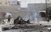 Security personnel gather at the scene of an explosion near the entrance of the airport in Somalia's capital Mogadishu February 13, 2014. REUTERS/Feisal Omar