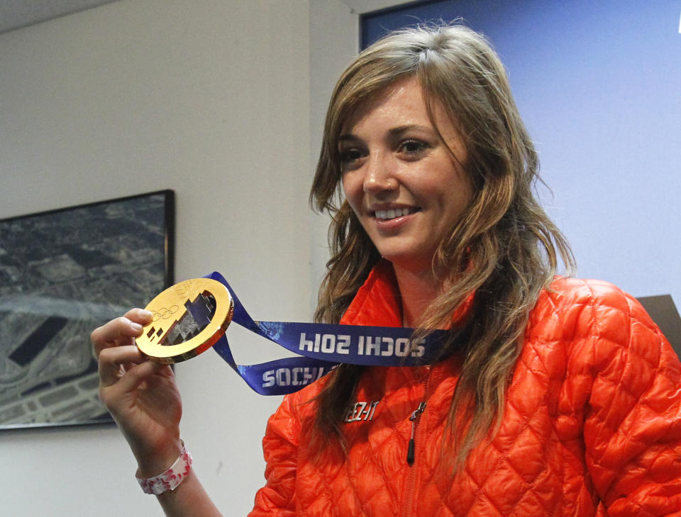 Olympic gold medalist Kaitlyn Farrington shows off her medal during a news conference before the NASCAR Daytona 500 Sprint Cup series auto race at Daytona International Speedway in Daytona Beach, Fla., Sunday, Feb. 23, 2014. (AP Photo/Terry Renna)
