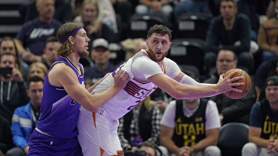 Utah Jazz forward Kelly Olynyk, left, guards Phoenix Suns center Jusuf Nurkic during the second half of an NBA basketball in-season tournament game Friday, Nov. 17, 2023, in Salt Lake City. (AP Photo/Rick Bowmer)