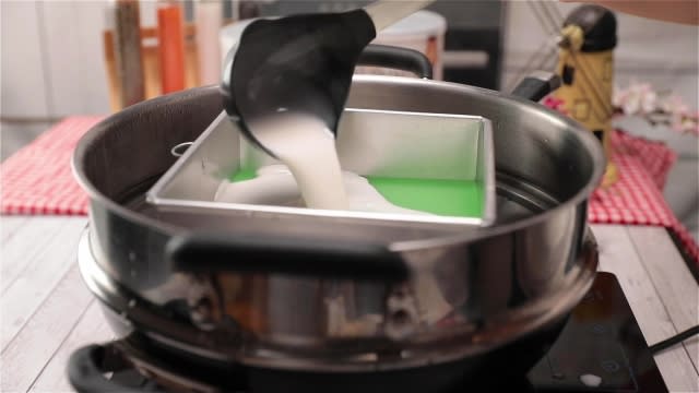 Pouring white kueh lapis batter into baking tin