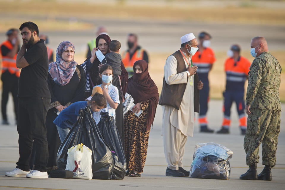 Evacuees from Afghanistan stand on the tarmac after disembarking from a U.S. airforce plane at the Naval Station in Rota, southern Spain, Tuesday Aug. 31, 2021. The United States completed its withdrawal from Afghanistan late Monday, ending America's longest war. (AP Photo/ Marcos Moreno)