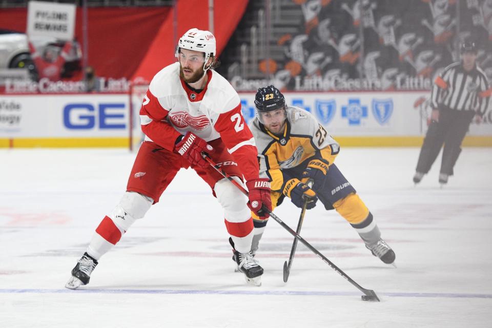 Detroit Red Wings center Michael Rasmussen (27) skates the puck up ice as Nashville Predators right wing Rocco Grimaldi (23) pursues during the second period April 6, 2021 at Little Caesars Arena.