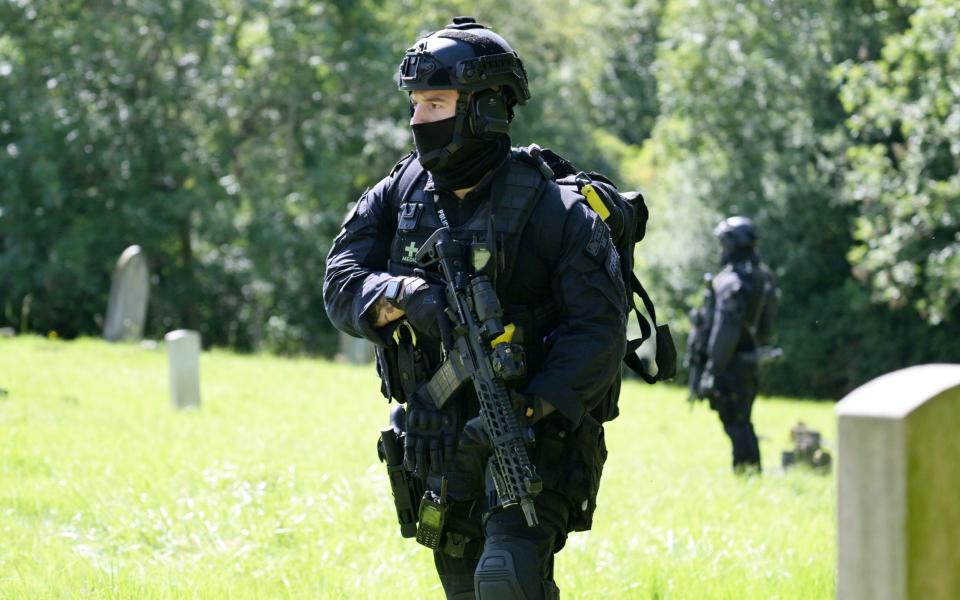 Armed police officers at Lavender Hill cemetery in Enfield as the hunt for suspected crossbow killer Kyle Clifford continues