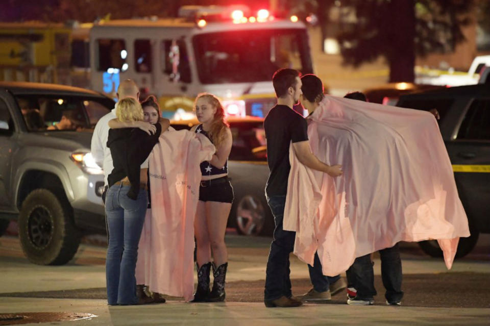 <p>Un grupo de jóvenes se protege del frío con mantas e intenta consolarse tras ser testigos del tiroteo llevado a cabo por un hombre en un bar de Thousand Oaks, un barrio a las afueras de Los Ángeles (California). (Foto: Mark J. Terrill / AP). </p>