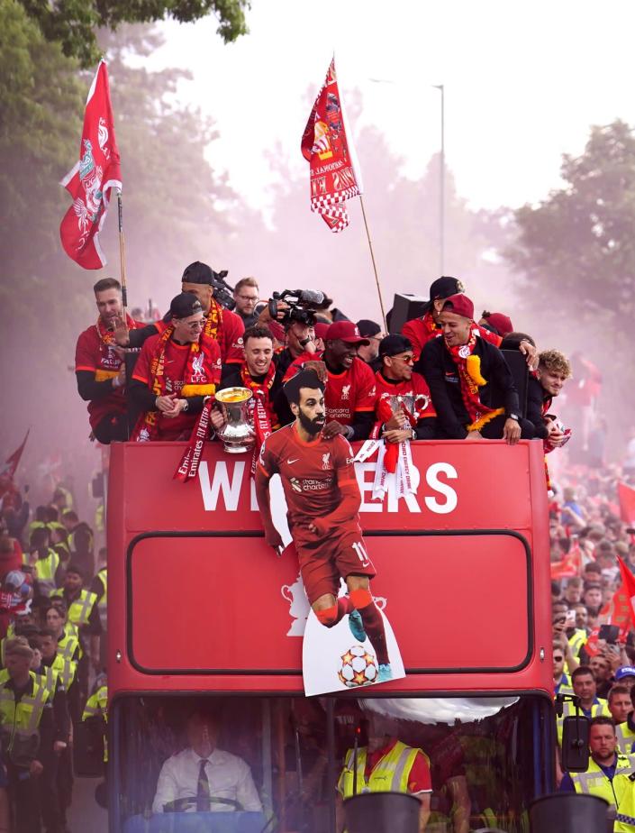 Liverpool players wave a cardboard cut-out of Mohamed Salah in front of the top deck of the bus (Martin Rickett/PA) (PA Wire)