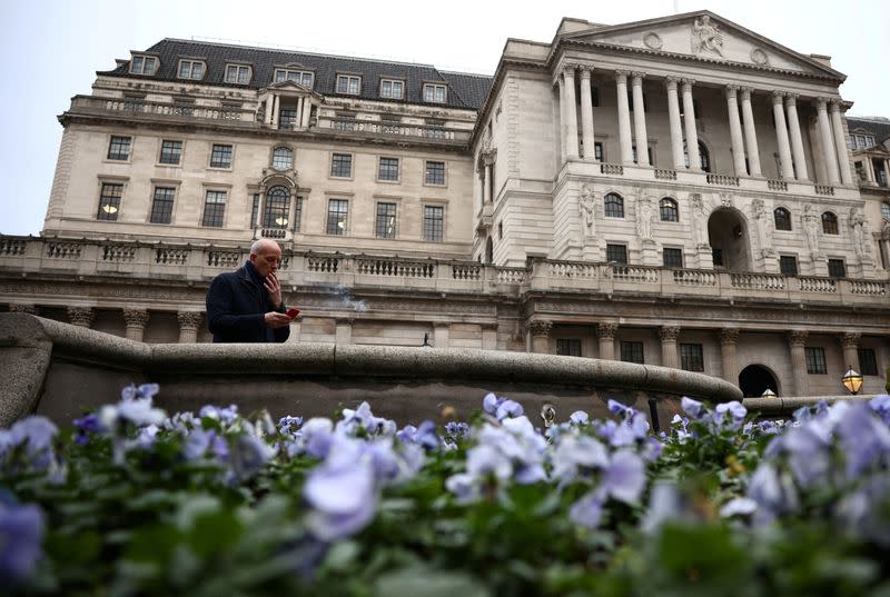 FILE PHOTO: A person smokes a cigarette outside the Bank of England in the City of London financial district, in London