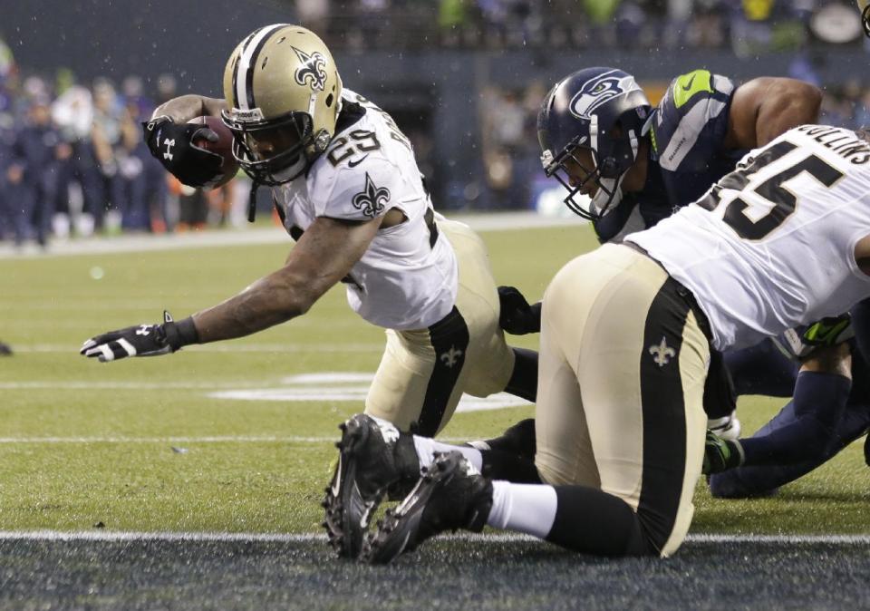 New Orleans Saints running back Khiry Robinson, left, runs for a 1-yard touchdown during the fourth quarter of an NFC divisional playoff NFL football game against the Seattle Seahawks in Seattle, Saturday, Jan. 11, 2014. (AP Photo/Elaine Thompson)