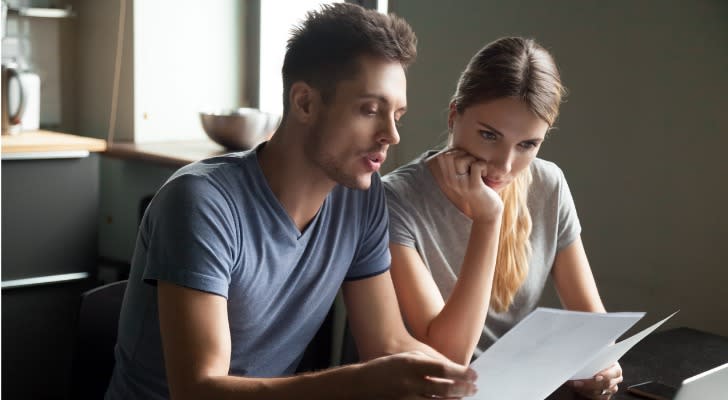 A couple looks over their assets and liabilities to calculate their net worth.