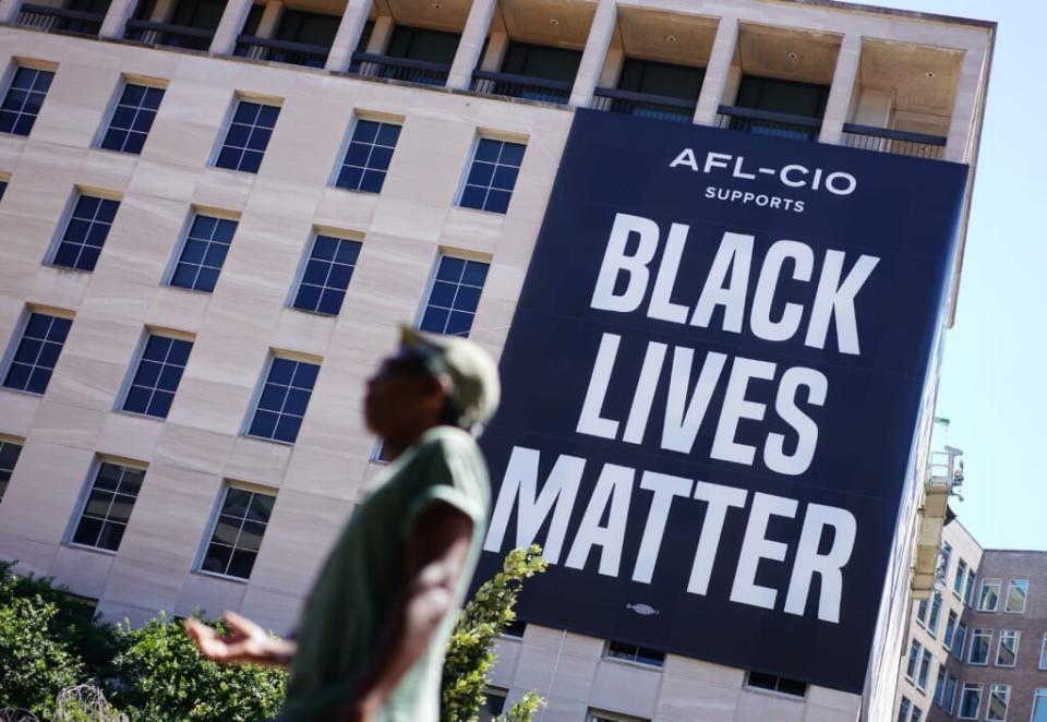 A man is seen in front of a large ‘Black Lives Matter’ banner on the side of the AFL-CIO building near the White House in Washington, DC on June 12, 2020. (Photo by MANDEL NGAN / AFP) (Photo by MANDEL NGAN/AFP via Getty Images)
