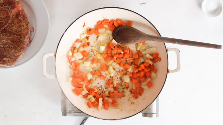 sauteed vegetables in pan with wooden spoon