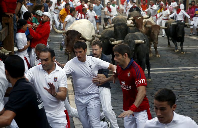 FILE PHOTO: Runners lead Miura fighting bulls during the last day of the running of the bulls of the San Fermin festival in Pamplona