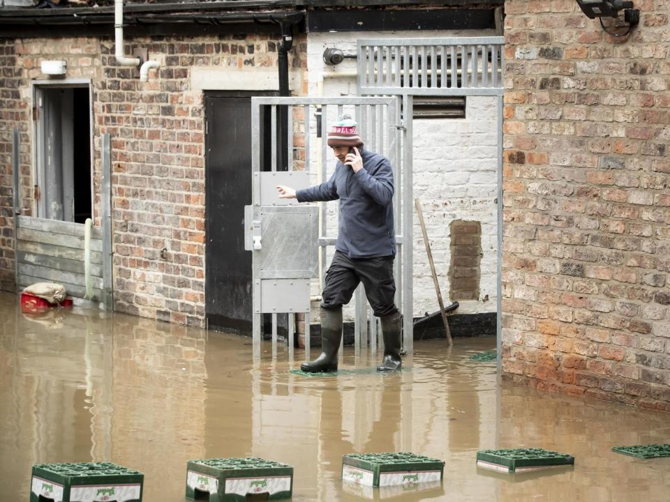 A man navigates flood water in York after the River Ouse burst its banks, as a third consecutive weekend of stormy weather is bringing further flooding misery to already sodden communities: PA