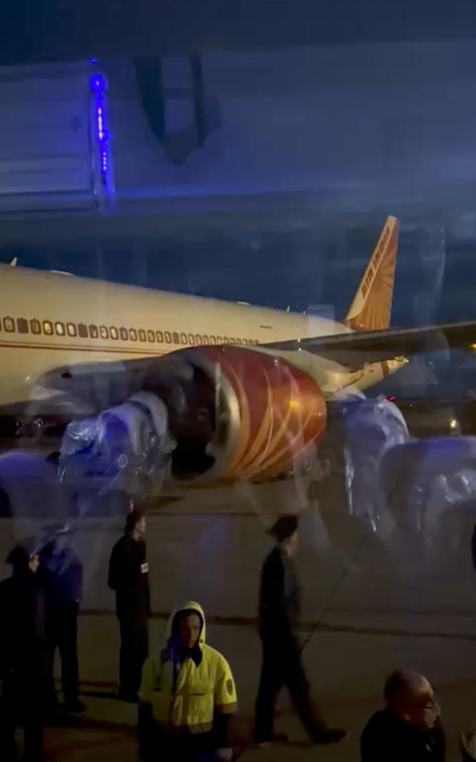 This image from video provided by passenger Girvaan Singh Kahma shows Air India's Boeing 777 after it landed at Russia's Magadan airport in Siberia on Tuesday, June 6, 2023. The plane that was flying from New Delhi to San Francisco, landed safely after it developed an engine problem, officials said on Wednesday. (Girvaan Singh Kahma via AP)
