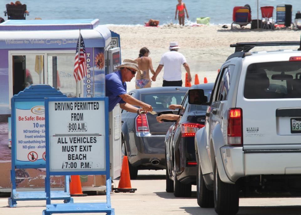 In this News-Journal file photo, a beach toll taker works a line of cars at the International Speedway Boulevard ramp. David Tucker/News-Journal