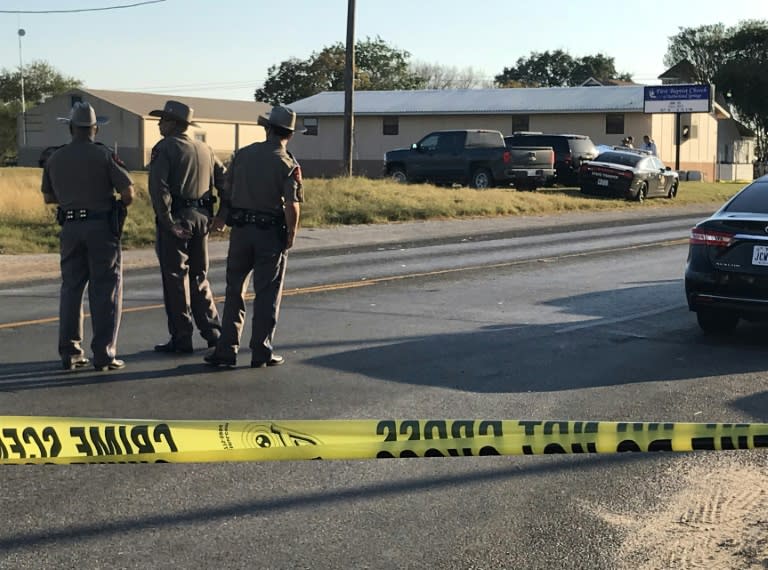 Police block a road in Sutherland Springs, Texas, on November 5, 2017, after a mass shooting at the the First Baptist Church (rear)