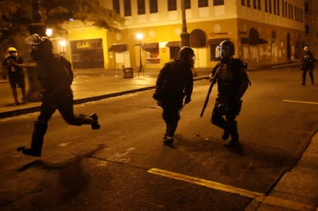 Police clash with demonstrators during a protest calling for the resignation of Governor Ricardo Rossello in San Juan