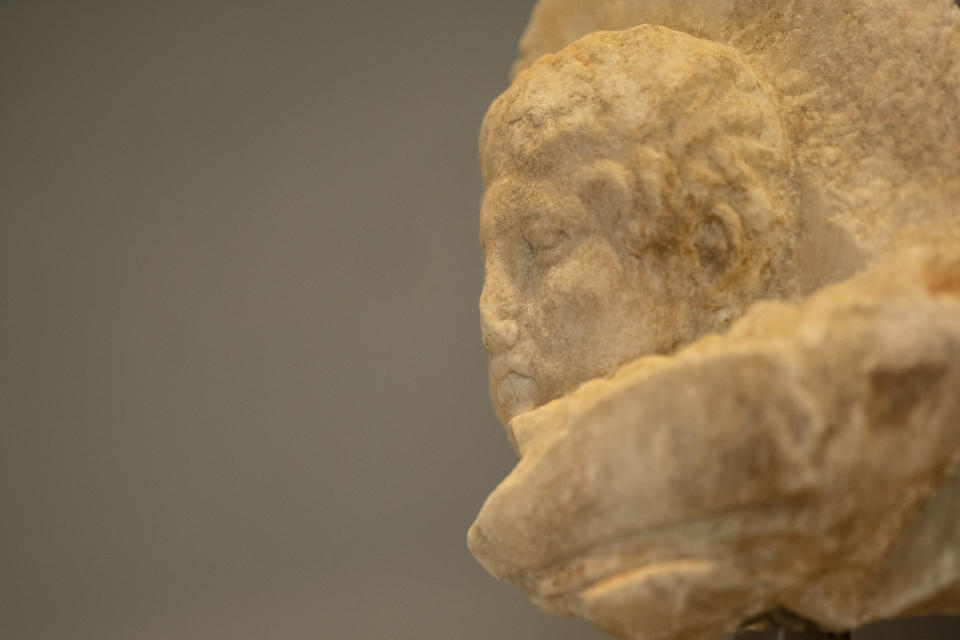 A newly placed male head, left, is seen on a frieze of the Acropolis museum during a ceremony for the repatriation of three sculpture fragments, in Athens, on Friday, March 24, 2023. Greece received three fragments from the ancient Parthenon temple that had been kept at Vatican museums for two centuries. Culture Ministry officials said the act provided a boost for its campaign for the return of the Parthenon Marbles from the British Museum in London. (AP Photo/Petros Giannakouris)