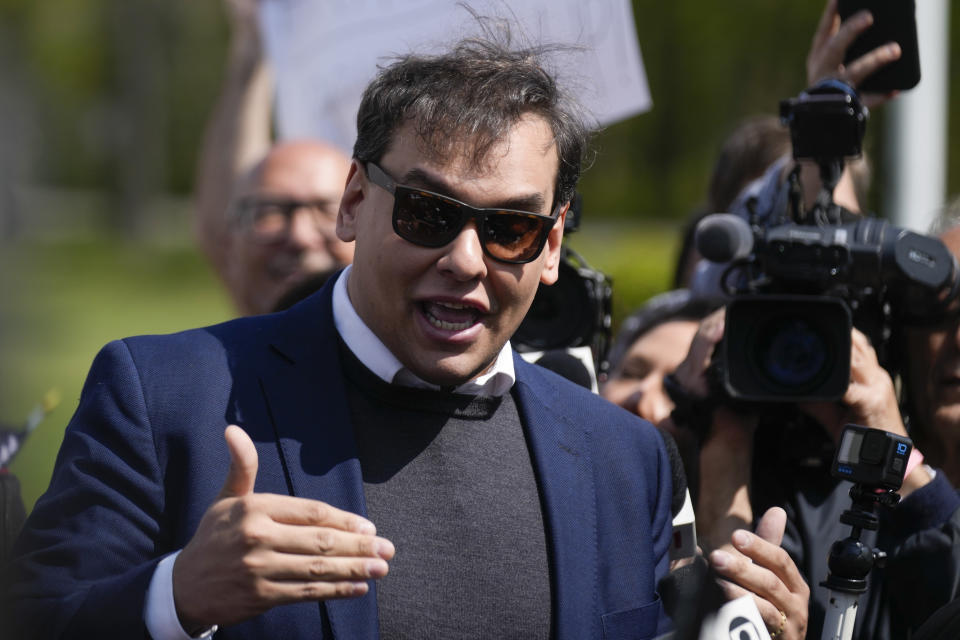 Rep. George Santos, R-N.Y., wearing sunglasses, speaks to reporters as he leaves the federal courthouse in Central Islip, N.Y.