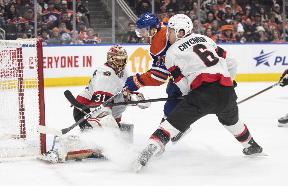 Ottawa Senators goalie Anton Forsberg (31) makes a save on Edmonton Oilers' Connor McDavid (97) as Jakob Chychrun (6) defends during the second period of an NHL hockey game Saturday, Jan. 6, 2024, in Edmonton, Alberta. (Jason Franson/The Canadian Press via AP)