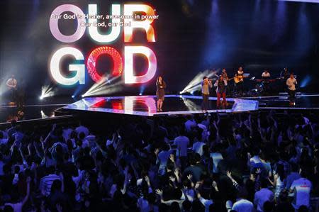 Worshippers attend a church service at the City Harvest Church in Singapore March 1, 2014. With a "prosperity gospel" that blends the spiritual and the material, City Harvest and other Pentecostal megachurches in the wealthy Asian city-state have perfected a popular and lucrative model. Now they are working to export it to the world and turn Singapore into a hub for evangelical Christianity. Picture taken March 1, 2014. REUTERS/Edgar Su