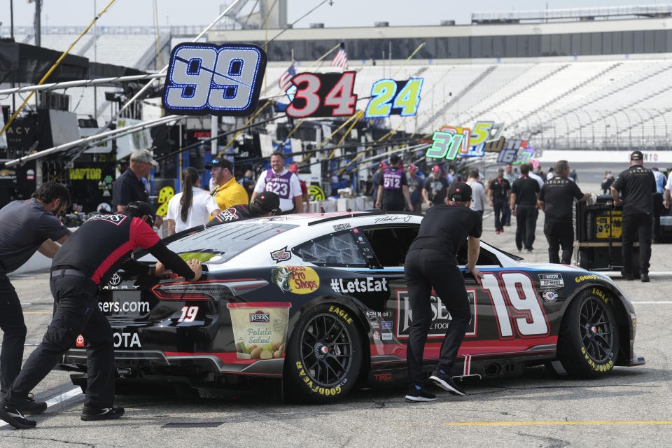 Race team members push the No. 19 car of Martin Truex Jr. onto the pit road before the Crayon 301 NASCAR Cup Series race Monday, July 17, 2023, at New Hampshire Motor Speedway, in Loudon, N.H. (AP Photo/Steven Senne)