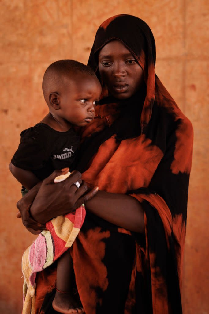 Kobra Yagoub-Sharaf and her daughter Eldin from Darfur pose for a portrait at the border with Chad and Sudan after their documents were processed in Adre, Chad, on April 20, 2024.