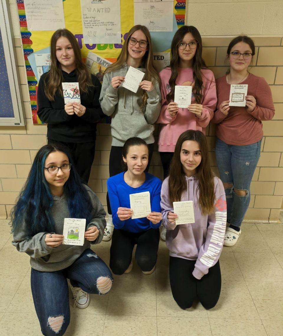 Jefferson Middle School seventh graders stand with books they created in Jennifer Young's social studies class. To create the book on ancient China, students were required to have titles, headings, bullet points and illustrations of the different dynasties they learned about.