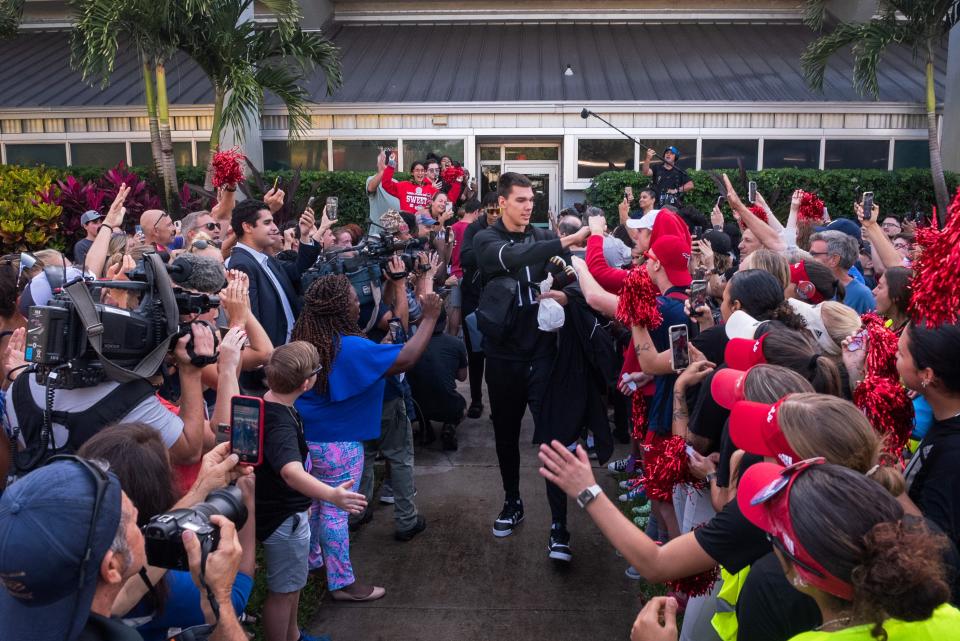 Florida Atlantic center Vladisov Goldin hi-fives fans while approaching the team bus at Baldwin Arena on Wednesday, March 29, 2023, in Boca Raton, FL. On Wednesday morning, the FAU men's basketball team departed for Houston, Texas, where they will play against San Diego State in the NCAA Tournament semi-final on Saturday.