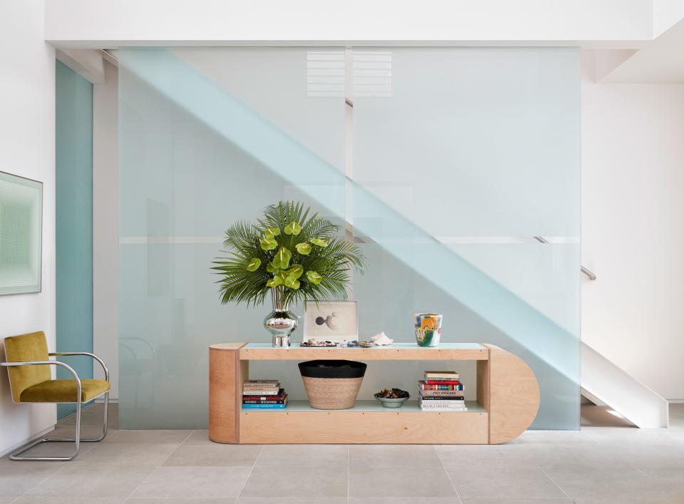 The stark minimalism of the entry hall in Kristen and Joe Cole's Dallas home is accentuated by a Formica-topped birch plywood console by Waka Waka, a furniture line from Los Angeles sold at Forty Five Ten. The painting is by Julian Stanczak, and the chair is a reupholstered Mies van der Rohe from Coming Soon.
