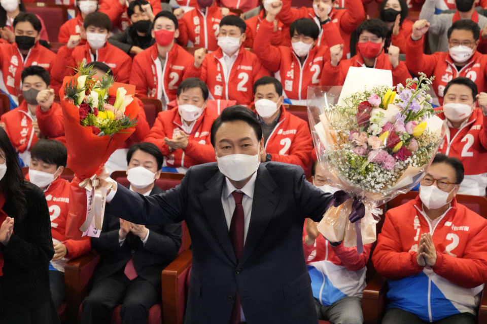 FILE - South Korean President-elect Yoon Suk Yeol holds bouquets as he is congratulated by party's members and lawmakers at the National Assembly in Seoul, South Korea on March 10, 2022. After winning a bitterly contested presidential election, South Korean conservative Yoon will enter office facing a quickly growing North Korean nuclear threat - and with few easy choices ahead to deal with it. (AP Photo/Lee Jin-man, Pool, File)