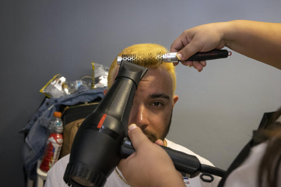 A fan of the Puerto Rico baseball team gets his hair dried after it was bleached as part of a mass hair dying event in an attempt to break the Guinness World Record for the most hair dyed in eight hours in Guaynabo, Puerto Rico, Friday, March 10, 2023. Going blond, which began as a joke among team members playing in California many years ago, was set up by fans to show support for their team competing at the World Baseball Classic. (AP Photo/Alejandro Granadillo)