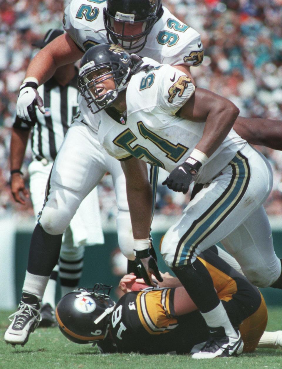 Jacksonville Jaguars rookie linebacker Kevin Hardy (51) gets up to celebrate his sack of Pittsburgh Steelers quarterback Jim Miller (16), joining defensive lineman Don Davey (92), in an NFL season opener on September 1, 1996. [Rick Wilson/Florida Times-Union]