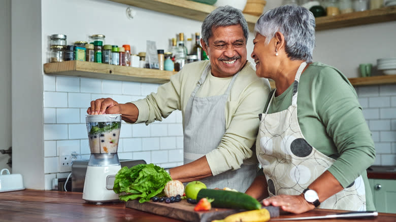 Older couple using blender in a kitchen