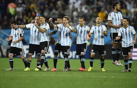 Argentina's Lionel Messi (L) and his teammates react after goalkeeper Sergio Romero makes a second save on a shot at goal by Wesley Sneijder of the Netherlands (unseen) during a penalty shootout in their 2014 World Cup semi-finals at the Corinthians arena in Sao Paulo July 9, 2014. REUTERS/Dylan Martinez