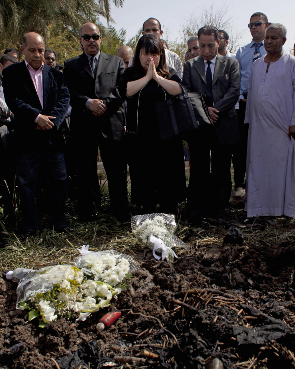 Japanese travel agent Okumura Hatsuko, center, pays respect to Japanese tourists that died from a hot air balloon accident, in Luxor, Egypt, Wednesday, Feb. 27, 2013. A hot air balloon carrying tourists over Egypt's ancient city of Luxor caught fire on Tuesday, Feb. 26, 2013 and some passengers trying to escape the flames leaped to their deaths before the craft crashed in a sugar cane field. At least 19 tourists were killed in one of the world's deadliest ballooning accidents. (AP Photo/Nasser Nasser)