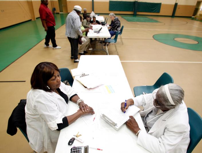 Christine Harrell, left, an intake worker with the CSRA Economic Opportunity Authority, helps a community member file paperwork for energy assistance in November 2011 at the Henry H. Brigham Center in south Augusta. The center was built in the 1990s and is in need of renovations.