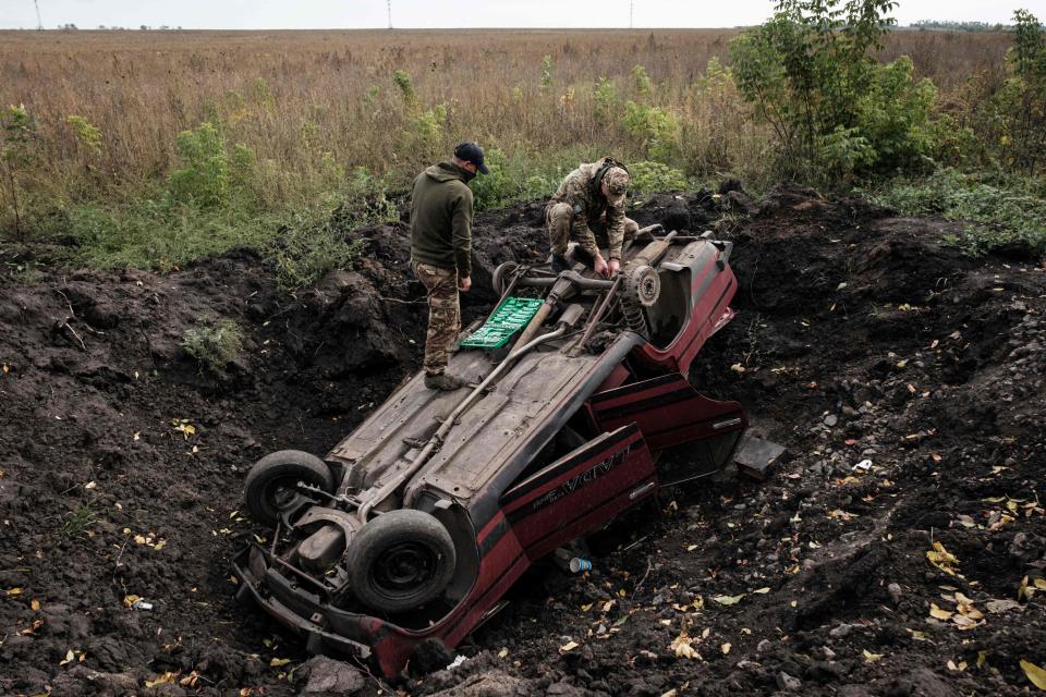 Ukrainian soldiers stand on top of a destroyed car near Prudyanka, Kharkiv region. (AFP via Getty Images)