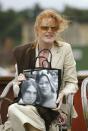 <p>In classic mom fashion, Sarah Ferguson shows off a bag printed with a photo of her daughters, Princesses Eugenie and Beatrice, at the Cowdray Park Polo Club. </p>