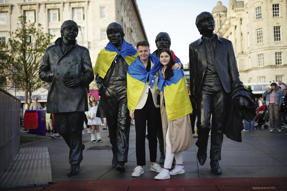 Aficionados colocan una bandera de Ucrania a una estatua en homenaje a los Beatles, antes de Eurovisión, en Liverpool, Inglaterra, el 12 de mayo de 2023. (Aaron Chown/PA via AP)